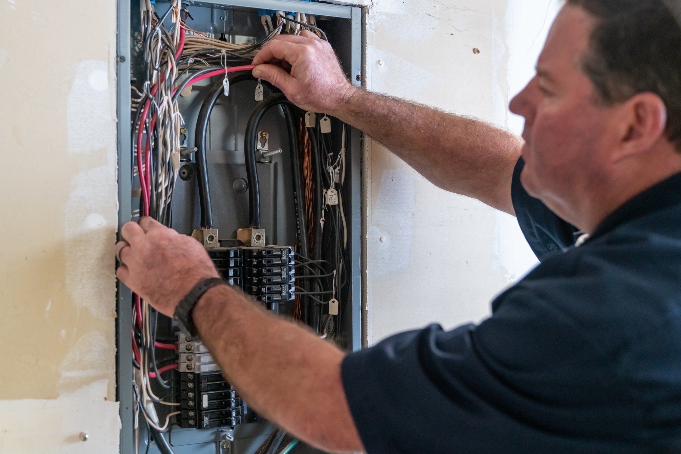 Electrician working on circuit breaker box